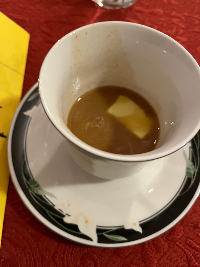 A china cup with something that looks a little like chai in the bottom